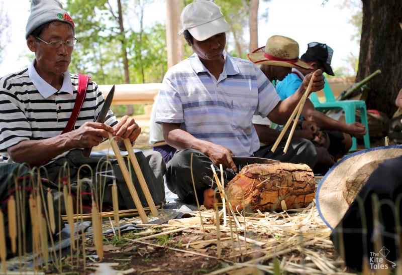 Men carve paddy models from bamboo