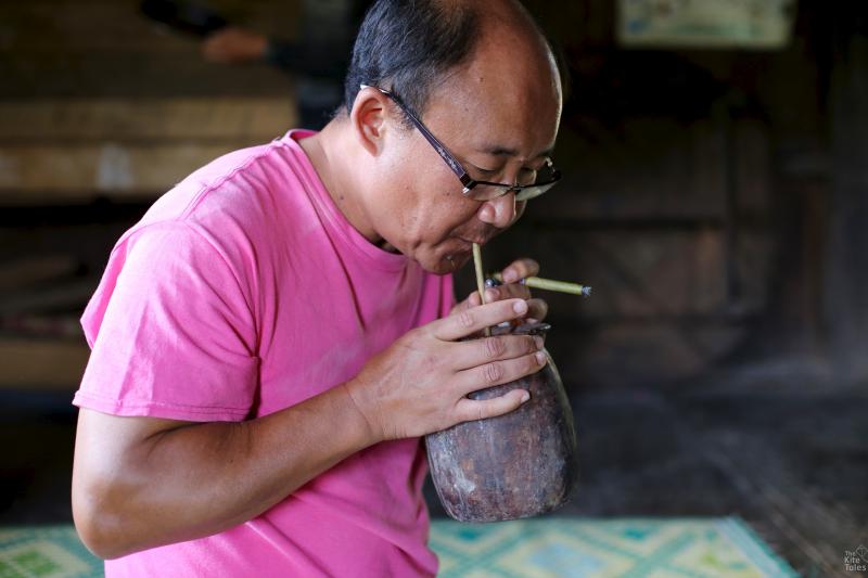 The author Pascal Khoo Thwe takes a sip during a trip in rural Kayah